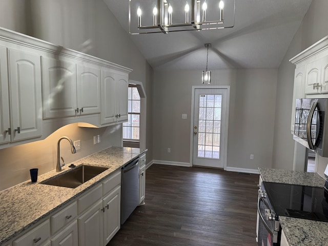 kitchen with lofted ceiling, sink, white cabinetry, appliances with stainless steel finishes, and pendant lighting