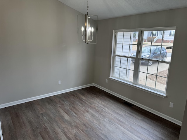 interior space featuring a textured ceiling, dark hardwood / wood-style floors, and a chandelier