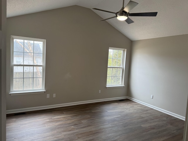 empty room with lofted ceiling, a textured ceiling, dark wood-type flooring, and ceiling fan