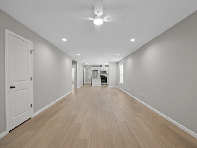 unfurnished living room featuring ceiling fan and light hardwood / wood-style flooring