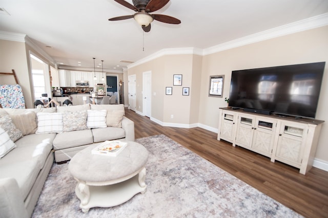 living room featuring crown molding, dark wood-type flooring, and ceiling fan