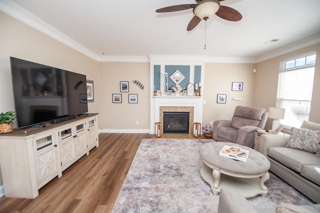 living room featuring hardwood / wood-style flooring, crown molding, and ceiling fan