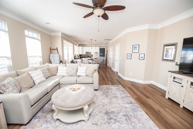 living room with hardwood / wood-style flooring, ornamental molding, and ceiling fan