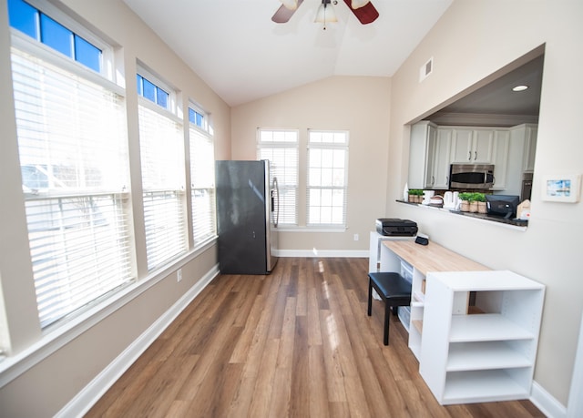 kitchen with butcher block counters, stainless steel appliances, light hardwood / wood-style floors, white cabinets, and vaulted ceiling