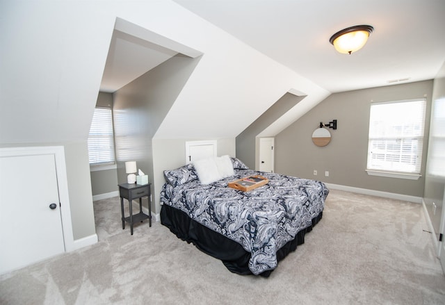 carpeted bedroom with lofted ceiling and multiple windows