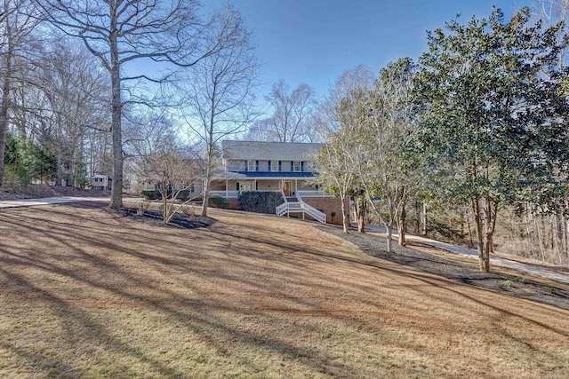 view of front of home featuring covered porch and a front lawn