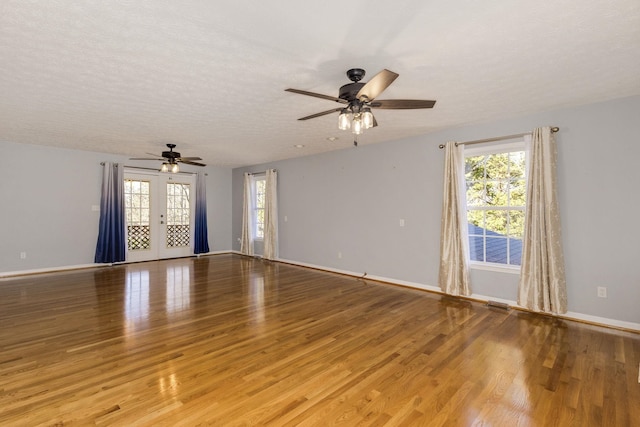 spare room with ceiling fan, a textured ceiling, and light wood-type flooring