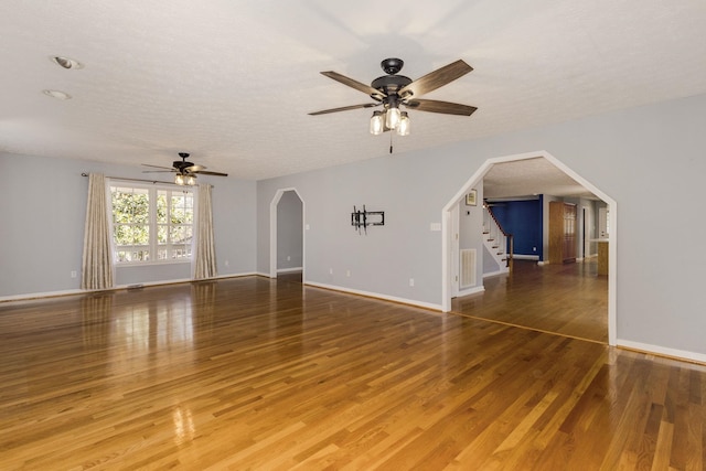 unfurnished living room with ceiling fan, hardwood / wood-style flooring, and a textured ceiling