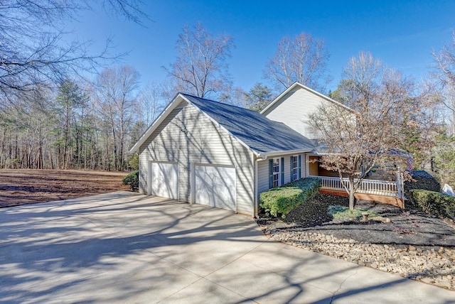 view of property exterior featuring a garage and covered porch