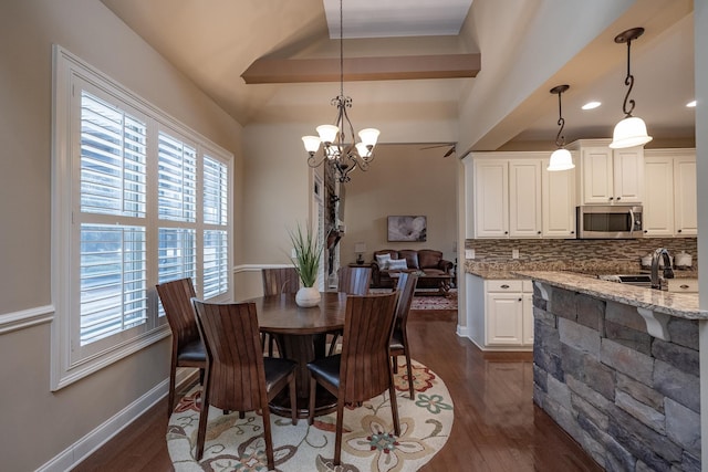 dining space with an inviting chandelier, a wealth of natural light, and dark wood-type flooring