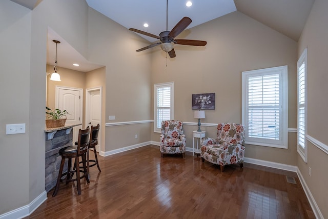 living area featuring high vaulted ceiling, dark hardwood / wood-style floors, and ceiling fan