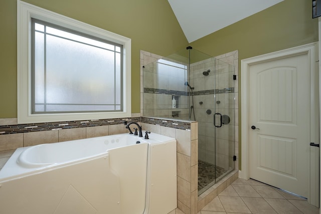 bathroom with tile patterned flooring, vaulted ceiling, and plus walk in shower