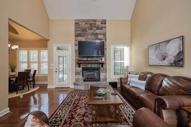 living room featuring an inviting chandelier, a fireplace, dark hardwood / wood-style floors, and high vaulted ceiling