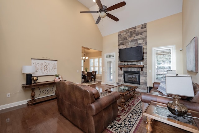 living room featuring high vaulted ceiling, ceiling fan with notable chandelier, a fireplace, and dark hardwood / wood-style flooring