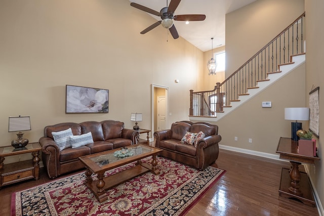 living room with ceiling fan, dark hardwood / wood-style flooring, and a high ceiling