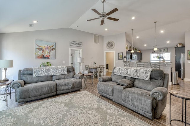 living room featuring ceiling fan, lofted ceiling, and light hardwood / wood-style floors