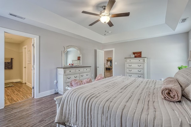 bedroom featuring hardwood / wood-style flooring, ceiling fan, and a raised ceiling