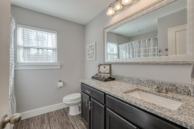 bathroom featuring vanity, wood-type flooring, and toilet