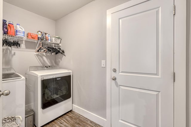 clothes washing area with dark hardwood / wood-style flooring and washer and dryer