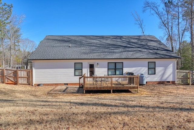 rear view of house featuring a wooden deck and a yard