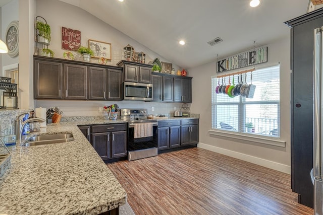 kitchen featuring lofted ceiling, appliances with stainless steel finishes, sink, and dark brown cabinets