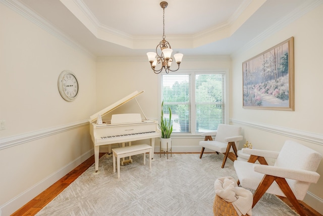 living area featuring crown molding, a tray ceiling, a chandelier, and hardwood / wood-style flooring