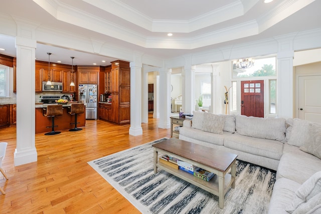 living room with a raised ceiling and decorative columns