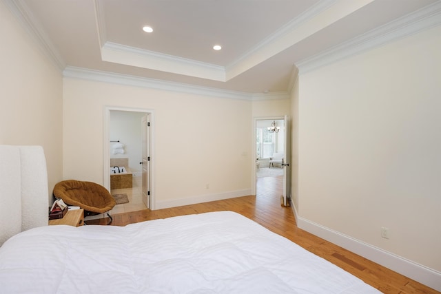 bedroom with a raised ceiling, crown molding, and light hardwood / wood-style floors