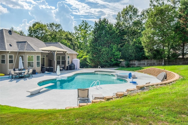 view of swimming pool with an in ground hot tub, a diving board, a lawn, and a patio area