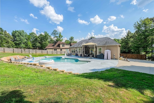 view of pool featuring a patio area, a lawn, and an in ground hot tub