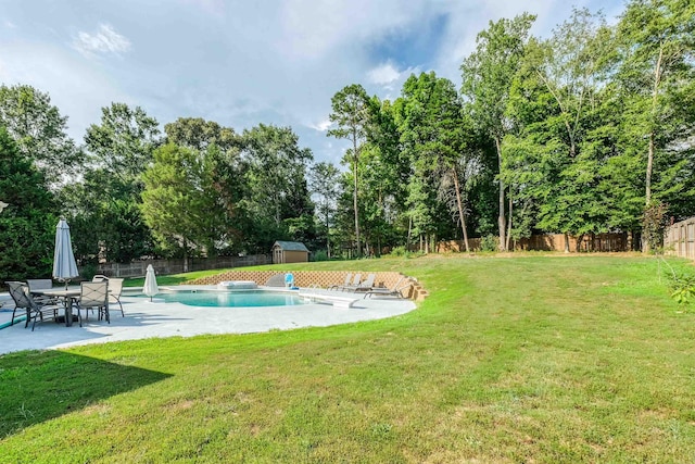 view of swimming pool with a water slide, a yard, a patio area, and a storage unit