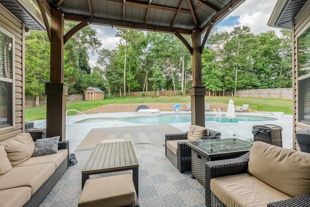 view of patio / terrace featuring an outdoor living space, a gazebo, a fenced in pool, and a storage shed