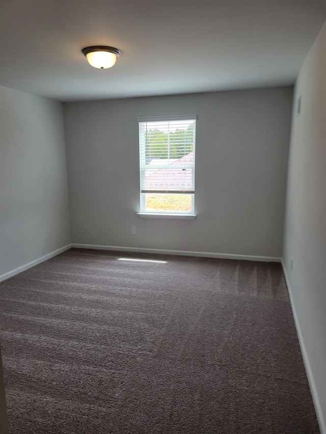 empty room featuring dark colored carpet