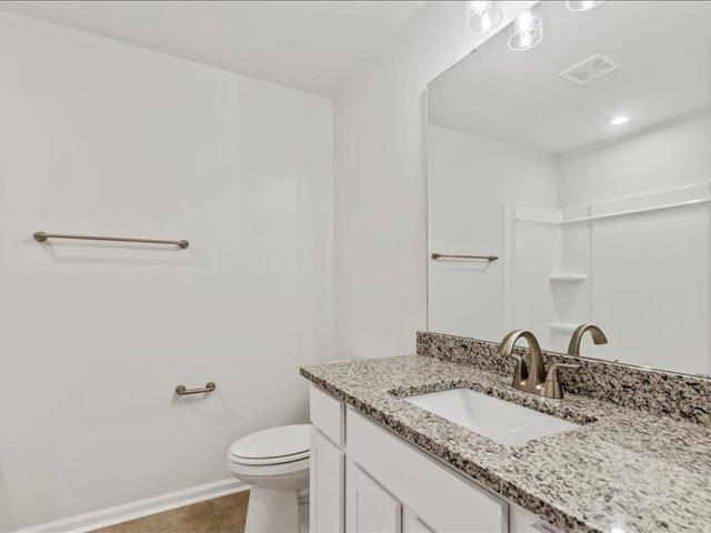 bathroom featuring vanity, tile patterned floors, and toilet