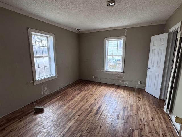 unfurnished bedroom featuring hardwood / wood-style flooring, ornamental molding, and a textured ceiling