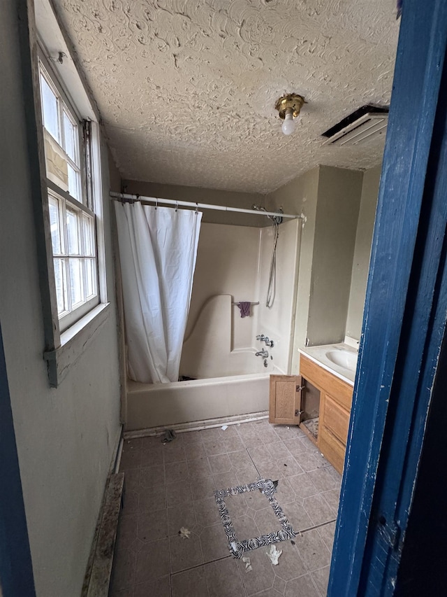 bathroom featuring vanity, a textured ceiling, and shower / bath combo with shower curtain