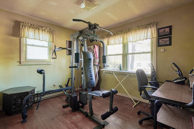 exercise room featuring wood-type flooring and a textured ceiling