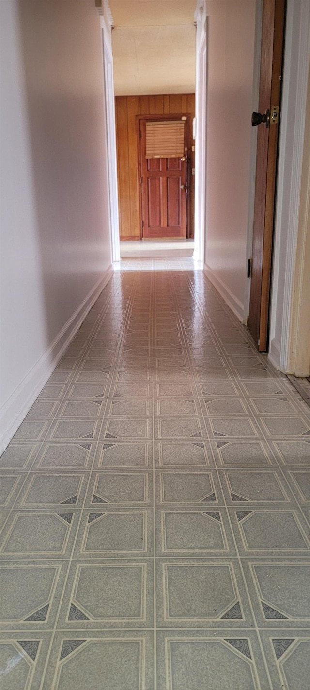 hallway with wood walls and baseboards
