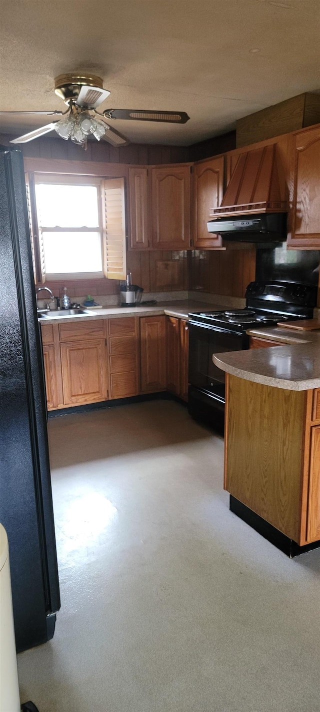 kitchen featuring premium range hood, a sink, ceiling fan, black appliances, and brown cabinetry