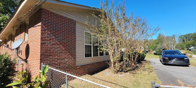 view of home's exterior featuring brick siding and aphalt driveway