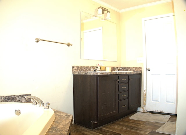 bathroom featuring hardwood / wood-style flooring, crown molding, a bathing tub, and vanity