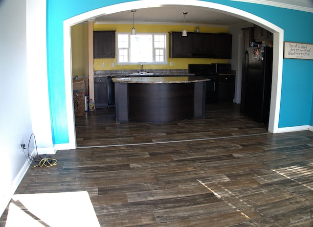 kitchen with sink, crown molding, black refrigerator, dark hardwood / wood-style floors, and decorative light fixtures