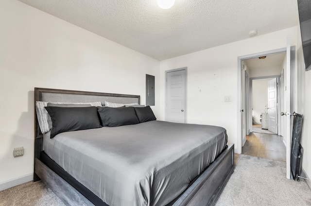 carpeted bedroom featuring electric panel and a textured ceiling