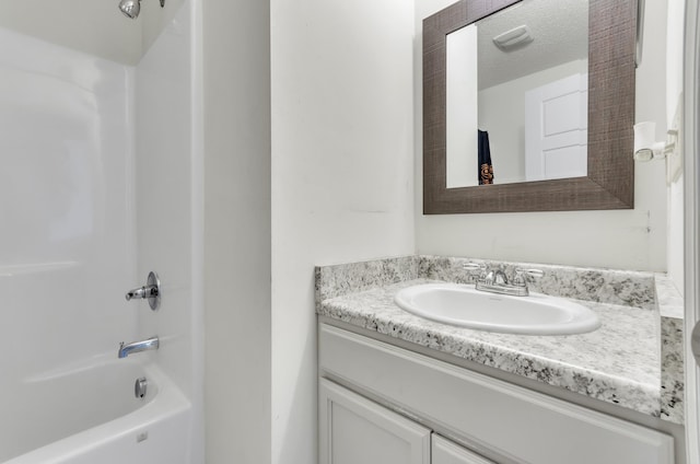 bathroom featuring shower / tub combination, vanity, and a textured ceiling