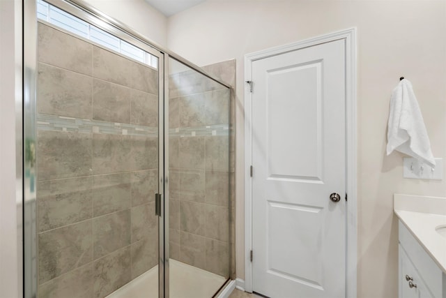 bathroom featuring vanity and a shower with door