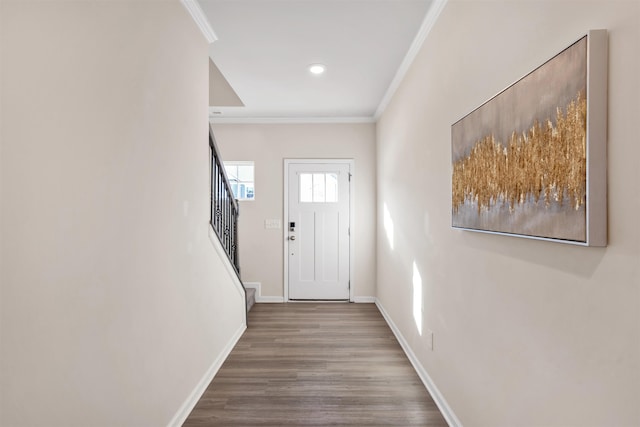 entryway with ornamental molding and hardwood / wood-style floors