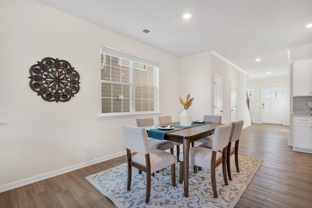 dining area with hardwood / wood-style flooring, plenty of natural light, and ornamental molding