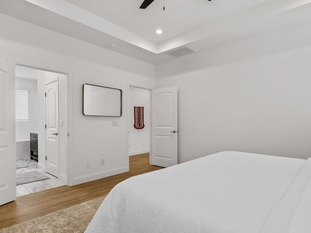 bedroom featuring wood-type flooring, ceiling fan, and ensuite bathroom