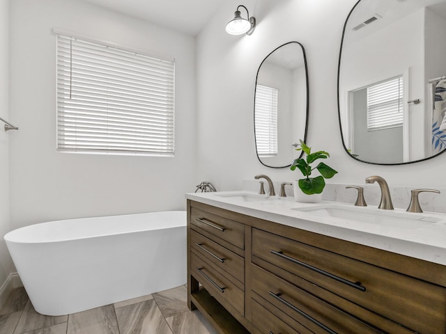 bathroom with vanity and a bath