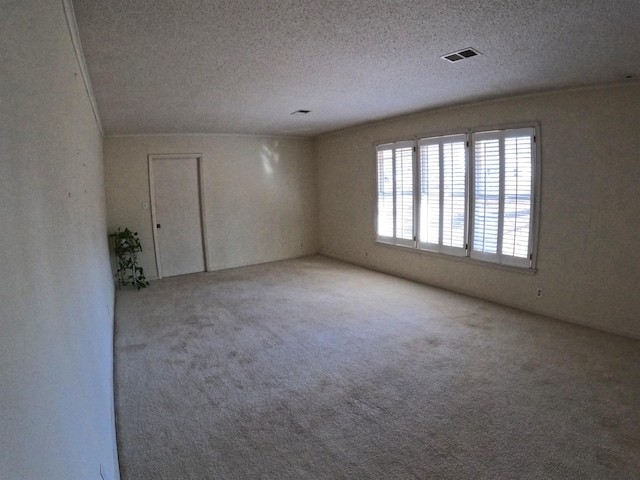 carpeted spare room with a textured ceiling